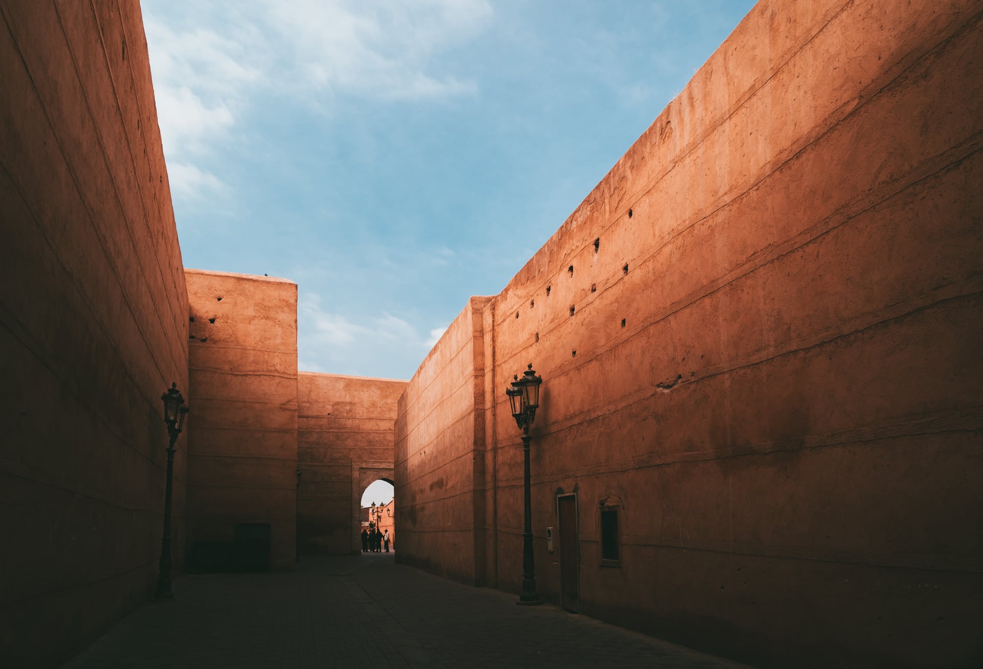 Ruelle de la médina de Marrakech entre deux hauts murs de terre ocre